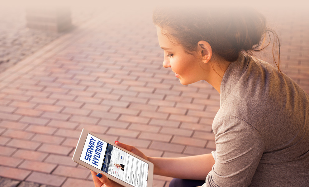 Young woman using her tablet to get pre-approved on the Seaway Hyundai website